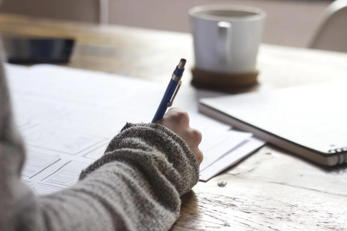 Student practicing scholarship essay writing in a notebook